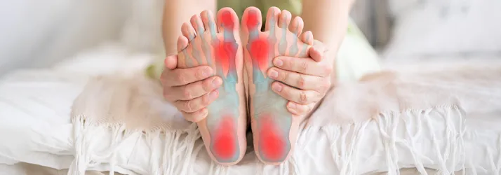 Chiropractic Orlando FL Foot Pain Person sitting on a bed with foot pain.