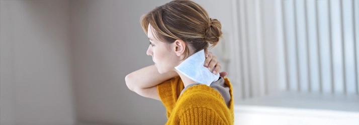 Chiropractic Orlando FL Woman With Heat Pad Person with a heat pad on their neck.